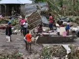 Una familia se reúne en medio de los escombros, en Les Cayes (Haití), tras el paso del huracán Matthew por la isla.