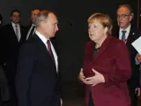 El presidente de Rusia Vladimir Putin (c-i) habla con la canciller alemana Angela Merkel.