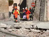 Efectivos de emergencias y bomberos italianos evacúan a algunos residentes del municipio de Norcia tras el terremoto.