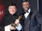 Jackie Chan sostiene su Óscar honorífico junto al actor Chris Tucker.
