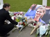 Un hombre deposita flores junto a una fotografía de la diputada laborista Jo Cox junto a las Casas del Parlamento en Londres (Reino Unido).