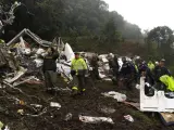 Varios miembros de los servicios de emergencia y agentes de la policía colombiana trabajan entre los restos del avión siniestrado.