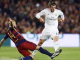 El delantero galés del Real Madrid, Gareth Bale (d), intenta llevarse el balón ante el defensa argentino del F. C. Barcelona, Javier Mascherano.