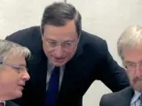 El presidente del BCE, Mario Draghi (C), conversa con el presidente del Banco de Francia, Christian Noyer (i), en presencia de Peter Praet, miembro del Comité Ejecutivo.