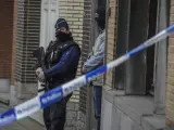 Policías belgas vigilan el exterior de una vivienda en el número 64 de la calle Busselenberg, en el distrito de Anderlecht-Bruselas, durante una redada en Bruselas.