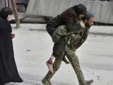 Un soldado sirio traslada a hombros a una mujer herida en la ciudad siria de Alepo.