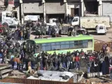 Civiles, combatientes y sus familiares, accediendo a uno de los autobuses durante los trabajos de evacuación de Alepo.