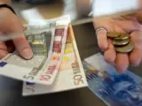 Fotografía de archivo tomada el 8 de junio de 2011 que muestra a una mujer cambiando francos suizos por euros en un mostrador en Kreuzlingen (Suiza).