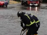 Bomberos destapando una alcantarilla en la calle de Colada de Pozuelo en Alcorcón.