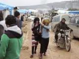 Un grupo de civiles sirios evacuados de la ciudad de Alepo caminan por un campo de refugiados en Idlib, Siria.