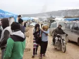 Un grupo de civiles sirios evacuados de la ciudad de Alepo caminan por un campo de refugiados en Idlib, Siria.