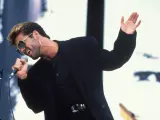 El cantante George Michael con la que fue su imagen más popular: pendiente de oro en forma de cruz, gafas con montura dorada, mechas y completamente vestido de negro.