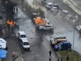 Imagen de varios vehículos envueltos en llamas mientras agentes de policía asisten a los heridos después de que explotara un coche bomba frente al Palacio de Justicia de Esmirna, en el oeste de Turquía.