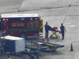 Efectivos de emergencias trasladan a víctimas del tiroteo en el aeropuerto de Lauderdale, en Florida, EE UU.