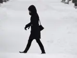 Una mujer pasea por un parque nevado en Sofía, Bulgaria.