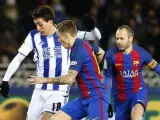 El delantero de la Real Sociedad Mikel Oyarzabal (i) disputa un balón con el defensa francés Lucas Digne (c) y el centrocampista Andrés Iniesta (d), del FC Barcelona, durante el partido de ida de cuartos de final de la Copa del Rey, que se jugó en el estadio de Anoeta de San Sebastián.