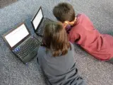 Dos niños con sus ordenadores portátiles.
