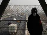 Un guardia de seguridad se protege con una mascarilla en Pekín. La capital china mantendrá la alerta naranja por contaminación hasta la madrugada del próximo jueves.