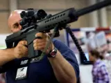 Un estadounidense porta un arma en una convención de la Asociación Nacional del Rifle.