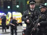 Agentes de policía británicos permanecen en guardia tras el ataque terrorista ante el Parlamento británico, en Londres.