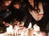 Varias personas encienden velas durante una vigilia en la plaza de Trafalgar, en Londres, para rendir tributo a las víctimas del atentado frente al Parlamento británico.