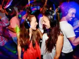 En la imagen varios jóvenes bailan en una discoteca.