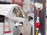 Un coche eléctrico, estacionado y enchufado en un punto de recarga.