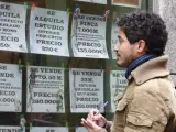 Un joven observa el escaparate de una inmobiliaria en Madrid.