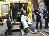 El reportero gráfico de la BBC Giles Wooltorton es trasladado en ambulancia tras ser atropellado por el vehículo del líder laborista, Jeremy Corbyn, antes de una reunión en Londres.