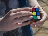 Una persona trata de resolver el cubo de Rubik.