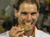 Rafa Nadal muerde su medalla de oro conseguida en el torneo de dobles masculinos en los Juegos de Río 2016.