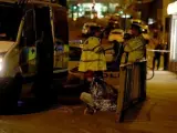 Una mujer, junto con un grupo de policías en una calle cerca del Manchester Arena, en Manchester, Reino Unido, donde se produjo una explosión al terminar un concierto de Ariana Grande, con el resultado de al menos 22 muertos.