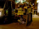Una mujer, con una manta térmica, es atendida junto a una furgoneta de la Policía en Manchester (Reino Unido), tras un atentado durante un concierto de Ariana Grande en el que han muerto al menos 22 personas, entre ellas varios niños, y otras 59 han resultado heridas.