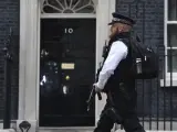 Un policía armado vigila la calle donde se encuentra el Nº 10 de Downing Street.