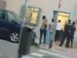Agentes de policía intenta entrar en una peluquería para reducir a un hombre que se ha refugiado en el establecimiento, tras amenazar a un ciudadano chino y comportarse de forma agresiva.