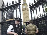 Un soldado británico y un policía patrullan por los alrededores del Parlamento de Londres.