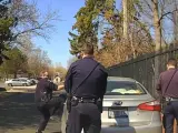 Un polic&iacute;a estadounidense rompe una ventanilla con sus manos para arrestar a un hombre.