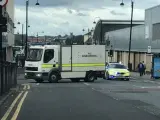 Imagen que muestra a un camión de artificieros de la Policía inglesa en el lugar donde un hombre, armado con un cuchillo, ha retenido a varios rehenes en Newcastle.