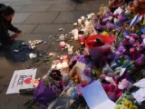 Decenas de ramos de flores amontonados cerca del Manchester Arena, durante una vigilia en honor a las víctimas del ataque terrorista en esta ciudad británica.