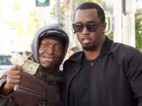 El cantante Sean 'P. Diddy' Combs le da un billete de 20 dólares a un 'sin techo' con el que a continuación se hace una foto en Beverly Hills (EE UU), el 2 de noviembre de 2011.