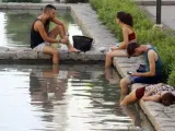 Unos jóvenes se refrescan en una de las fuentes del centro de Córdoba.