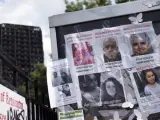 Varias imágenes de personas desaparecidas en el incendio de la torre Grenfell (al fondo), al oeste de Londres.