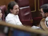 El secretario general de Podemos, Pablo Iglesias, conversa con el coordinador general de IU, Alberto Garzón.