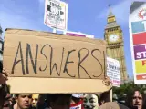 Un grupo de manifestantes con pancartas durante una protesta en las inmediaciones del Parlamento británico, con motivo del incendio en la torre Grenfell.