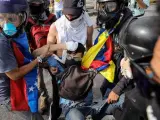 Un grupo de manifestantes auxilia a David José Vallenilla, de 22 años, tras recibir éste un disparo de un miembro de la Guardia Nacional Bolivariana durante una marcha opositora en Caracas (Venezuela). El joven murió poco después.