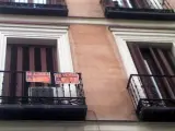 En el balcón de un piso el cartel de Se Vende y Se Alquila.