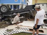 Richard Garner (i) saca una bolsa para secar los dispositivos móviles mojados de los restos de su casa después del paso del huracán 'Harvey', en Rockport, Texas (EE UU).