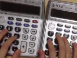 Un hombre toca Despacito, de Luis Fonsi, con dos calculadoras.