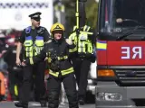Bomberos y policías caminan junto a la estación de metro Parsons Green en Londres tras la explosión de una bomba.