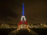 Vista de la torre Eiffel iluminada con los colores de la bandera nacional francesa en París, en homenaje a las víctimas de los atentados perpetrados por el Estado Islámico (EI) en noviembre de 2015.